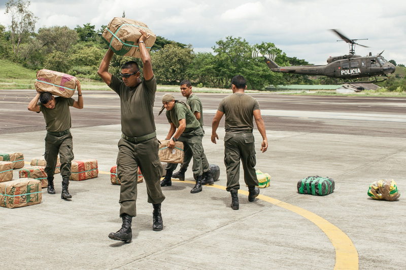 Photo Anti-narcotics police load up six tonnes of marijuana disguised as sugar, which they have just confiscated after searching lorry in the Valle de Cauca. Right, Embera indians bring their platano crop downriver for loading and shipping down the coast. 