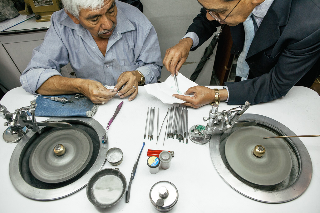 Photo An artisan in Bogotá inspects which emeralds to polish. 